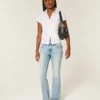 Låg midja, medium tvätt, broderade bootcut-jeans med fjärilsmotiv