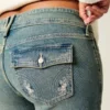 Lågmidjade bootcut-jeans med fjärilsbroderi i medium tvätt Lågmidjade bootcut-jeans med fjärilsbroderi i medium tvätt