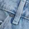 Lågmidjade, ljusblå baggyjeans med nitar och rosetter Lågmidjade, ljusblå baggyjeans med nitar och rosetter