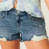 Lågmidjade minishorts i mediumtvättad denim med slitna detaljer Lågmidjade minishorts i mediumtvättad denim med slitna detaljer
