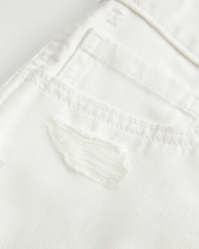 Lågmidjade minishorts i vit denim med slitna detaljer Lågmidjade minishorts i vit denim med slitna detaljer