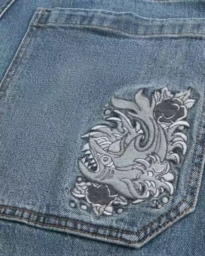 Mediumtvättade skaterbaggyjeans med broderad hajgrafik Mediumtvättade skaterbaggyjeans med broderad hajgrafik