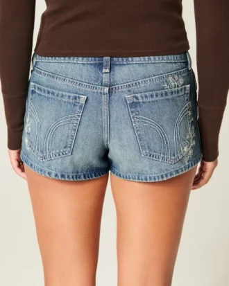 Ultra låg midja, medium tvätt, minishorts i denim med blommig brodyr