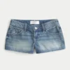 Ultra låg midja, medium tvätt, minishorts i denim med blommig brodyr Ultra låg midja, medium tvätt, minishorts i denim med blommig brodyr