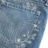 Ultra låg midja, medium tvätt, minishorts i denim med blommig brodyr Ultra låg midja, medium tvätt, minishorts i denim med blommig brodyr